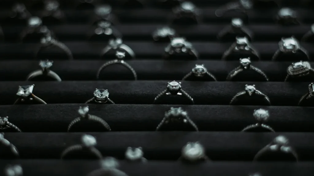 Selección de anillos de compromiso de diferentes estilos, metales y piedras expuestos sobre fondo de terciopelo oscuro, mostrando la calidad real que se puede conseguir con distintos presupuestos lógicos