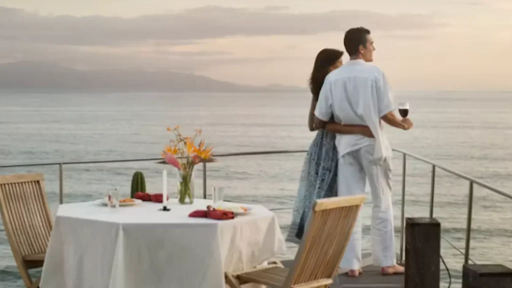 Mesa preparada para cena romántica en terraza de hotel con velas y vista nocturna al mar sin texto ni personas visibles, representando los servicios de valor real de la luna de miel que sí merecen pagarse pero contratados directamente sin pasar por el paquete de agencia