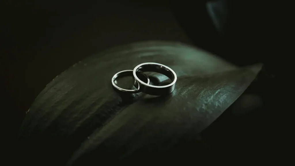 Comparativa de alianzas de boda de diferentes estilos y acabados expuestas sobre fondo oscuro neutro, mostrando la misma calidad de oro 18 quilates disponible a precios muy distintos según el canal de compra