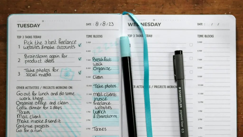 Reloj de pared clásico junto a agenda abierta con horarios y notas escritas a mano sin texto legible, representando la metodología de planificación del cronograma del día de la boda con tiempos colchón para absorber retrasos en cadena
