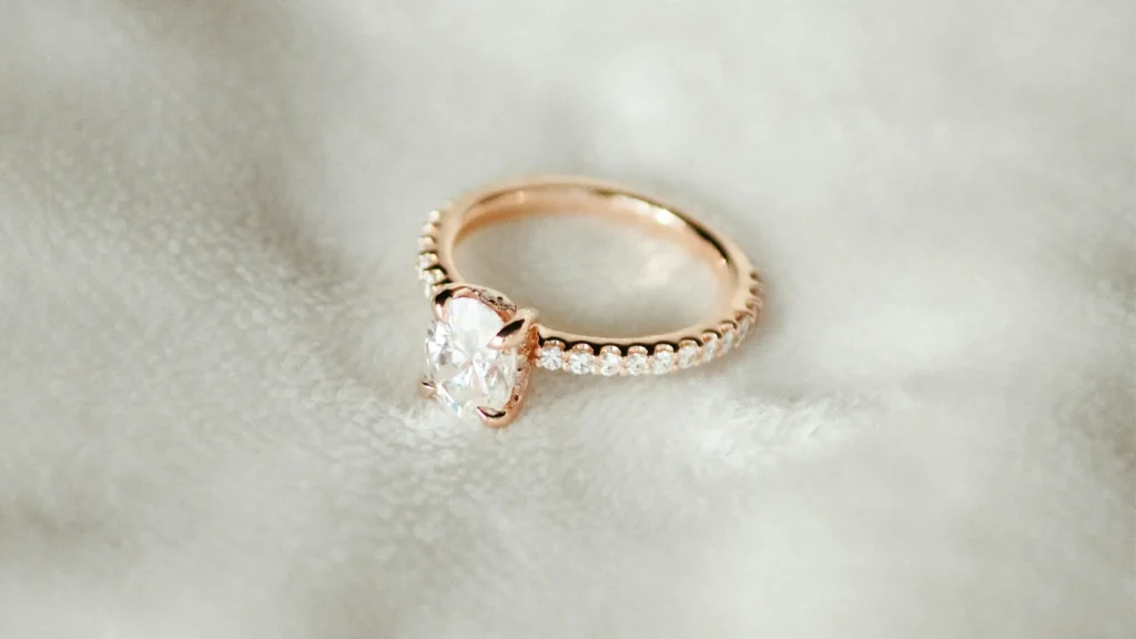 Anillo de compromiso con diamante solitario sobre superficie de mármol blanco sin elementos decorativos, representando una guía real sobre cuánto gastar en el anillo sin dejarse llevar por el marketing nupcial