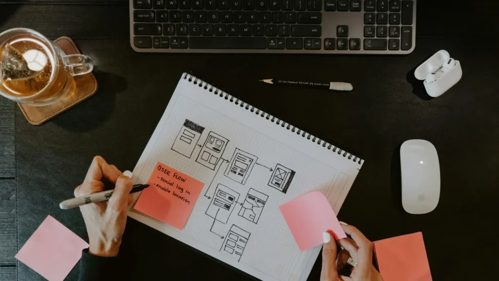 Mesa de trabajo con diagrama de planificación notas adhesivas y portátil abierto con hoja de cálculo sin personas visibles, representando cómo organizar una boda paso a paso aplicando gestión de proyecto profesional para cumplir plazos y presupuesto en 2026
