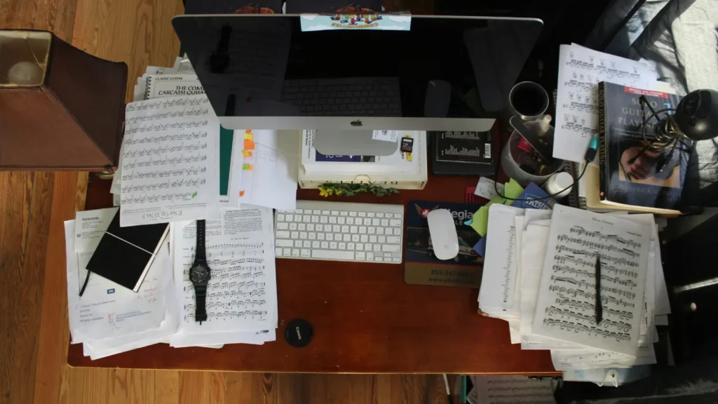 Contraste entre escritorio con documentos desorganizados y recibos arrugados frente a portátil con hoja de cálculo ordenada, representando la diferencia entre gestionar los pagos a proveedores de boda con libreta y memoria versus un sistema de registro estructurado